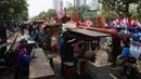 Pedagang kaki lima menjajakan barang dagangan saat Demo Hari Buruh di Jakarta, Selasa (1/5). Pedagang kaki lima ini memanfaatkan Hari Buruh untuk mengais rejeki dengan berjualan saat demontrasi berlangsung. (Liputan6.com/Johan Tallo)