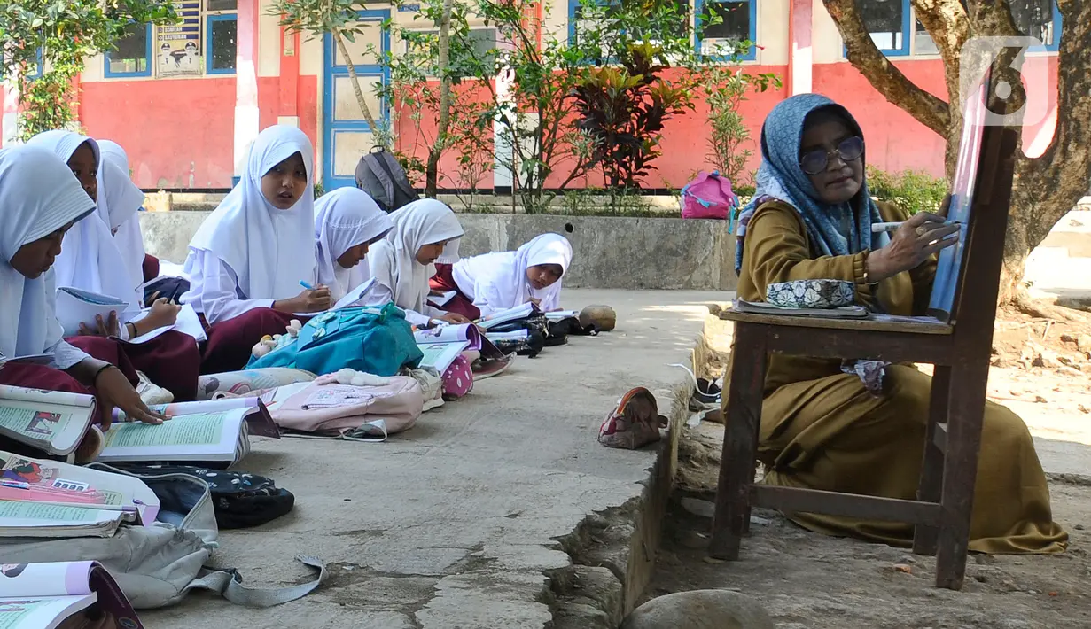 Guru saat mengajar di halaman sekolah di SDN Sukagalih, Kampung Benda, Desa Mekargalih, Kecamatan Cikalong Kulon, Cianjur Senin (29/8/2022). Akibat tiga ruangan kelas rusak berat dan terancam ambruk, sejumlah murid terpaksa belajar di halaman dan musholla sejak awal pembelajaran tatap muka Juli kemarin. (merdeka.com/Arie Basuki)