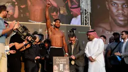 Petinju kelas berat Anthony Joshua (tengah) mengangkat tangannya saat timbang badan resmi di Riyadh, Arab Saudi, Jumat (6/12/2019). Anthony Joshua menantang Andy Ruiz Jr untuk merebut kembali sabuk juara kelas berat WBA, WBO, dan IBF. (AP Photo/Hassan Ammar)