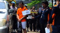 Anggota Densus 88 Bripda Haris Sitanggang alias Bripda HS menjalani rekonstruksi pembunuhan sopir taksi online Sony Rizal Taihitu (56) di lapangan Direktorat Reserse Kriminal Umum Polda Metro Jaya, Jakarta, Kamis (16/2/2023). Bripda HS menjalani 37 adegan sebagai rangkaian peristiwa pembunuhan Sony Rizal Taihitu di Jalan Nusantara Perumahan Bukit Cengkeh, Kelurahan Tugu Cimanggis, Depok, Jawa Barat. (merdeka.com/Imam Buhori)