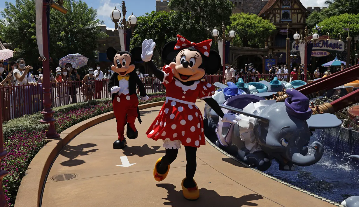 Karakter Minnie dan Mickey Mouse melambai kepada pengunjung di Disneyland Hong Kong, Kamis (18/6/2020). Disneyland Hong Kong kembali beroperasi pada 18 Juni 2020 dengan menerapkan sejumlah protokol kesehatan baru untuk mencegah penyebaran COVID-19. (AP Photo/Kin Cheung)