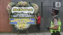 Petugas meletakkan karangan bunga duka cita atas meninggalnya Ratu Elizabeth II di depan Kedutaan Besar (Kedubes) Inggris, kawasan Kuningan, Jakarta, Jumat (9/9/2022). Duka tengah menyelimuti rakyat Inggris setelah meninggalnya Ratu Elizabeth II. (Liputan6.com/Herman Zakharia)