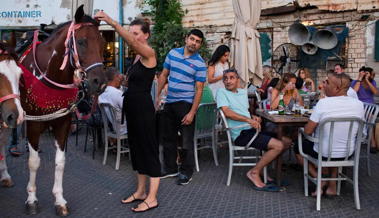 Wisatawan duduk di sebuah restoran pelabuhan Jaffa, Israel, 21 Juli 2018. Jaffa merupakan pelabuhan tertua di dunia. (AP Photo/Oded Balilty)