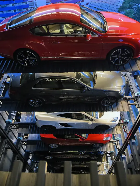 Mobil mewah yang dijual menggunakan konsep vending machine (mesin penjual otomatis) di gedung Autobahn Motors, Singapura, Kamis (18/5). Fasilitas ini memiliki 60 slot dan menjadikannya sebagai vending machine mobil mewah terbesar dunia (ROSLAN RAHMAN/AFP)