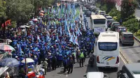 Ratusan buruh mulai terlihat berkumpul di sekitar kawasan Patung Kuda, Jakarta, Selasa (1/8/2015). Mereka menuntut pemerintah menghentikan gelombang PHK yang mengancam akibat melemahnya nilai tukar rupiah terhadap dolar. (Liputan6.com/Gempur M Surya)