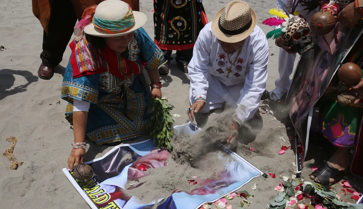 Dukun Peru meletakkan pasir ke atas poster bergambar Capres AS dari Partai Republik, Donald Trump, saat dukun Peru melakukan ritual prediksi menjelang pemilihan presiden AS, di Lima, Peru, Senin (7/11). (REUTERS/Mariana Bazo)