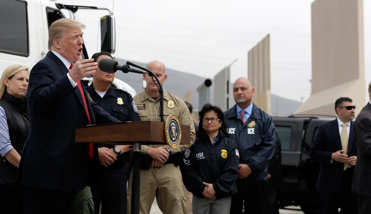 Presiden AS, Donald Trump memberikan keterangan kepada awak media seusai meninjau prototipe tembok perbatasan AS dan Meksiko di San Diego, Selasa (13/3). Tembok setinggi 30 kaki itu dibangun Trump untuk mencegah masuknya imigran gelap. (AP/Evan Vucci)