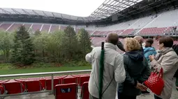 Pengunjung melihat instalasi ekosistem hutan di Stadion Woerthersee, Austria, Minggu (8/9/2019). Lebih dari 300 pohon berbagai jenis , mulai dari pohon aspen, ek, betula, hingga larix ditancapkan dalam karya seni yang berjudul "The Unending Attraction of Nature". (AP/Ronald Zak)