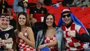Dua fans wanita Kroasia bersama rekannya menghadiri pertandingan Grup F Piala Dunia Qatar 2022 antara Kroasia dan Belgia di Stadion Ahmad Bin Ali di Al-Rayyan, barat Doha pada 1 Desember 2022. (AFP/Gabriel Bouys)