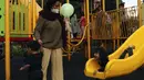 Anak-anak didampingi orangtua bermain di RPTRA Bhineka Jakarta Selatan, Sabtu (30/7/2022). Selain menjadi alternatif mengisi libur bersama keluraga, taman juga menjadi ruang bagi warga untuk berinteraksi sosial sekaligus mengeduksi anak untuk bermain bersama teman-teman dengan wahana yang tersedia. (Liputan6.com/Johan Tallo)