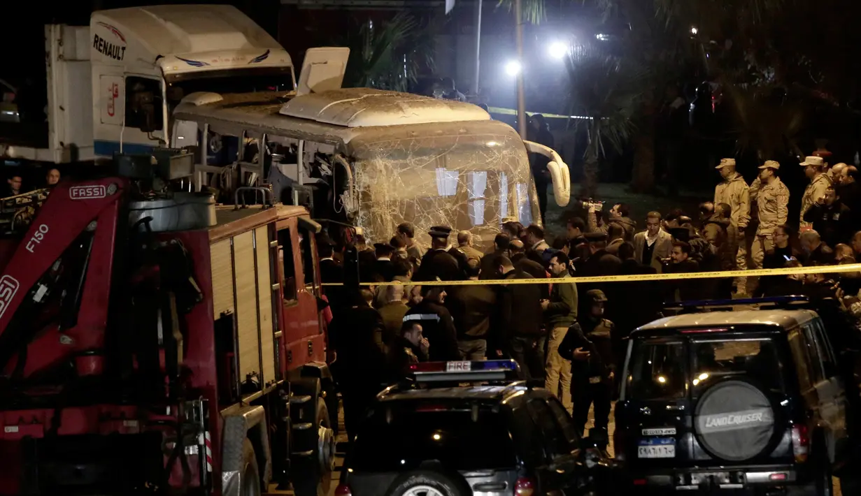 Pasukan keamanan berdiri di dekat sebuah bus wisata setelah serangan bom pinggir jalan di sebuah daerah dekat Piramida Giza di Kairo, Mesir (28/12). Insiden tersebut menewaskan  dua turis Vietnam dan 12 lainnya terluka. (AP Photo/Nariman El-Mofty)