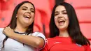 Dua suporter Timnas Inggris tersenyum melihat aksi anak asuh Gareth Southgate yang mampu menang dua gol tanpa balas atas Timnas Jerman. (Justin Tallis/Pool/AFP)