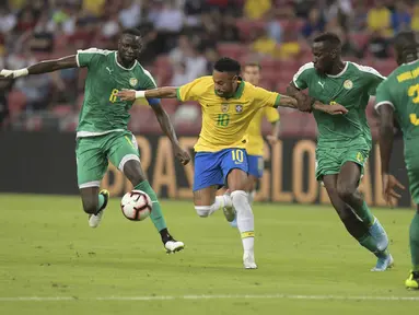 Penyerang Brasil, Neymar berusaha mengontrol bola dari kawalan tiga pemain Senegal pada pertandingan persahabatan di Stadion Nasional di Singapura (10/10/2019). Brasil bermain imbang dengan Senegal 1-1. (AFP Photo/Roslan Rahman)