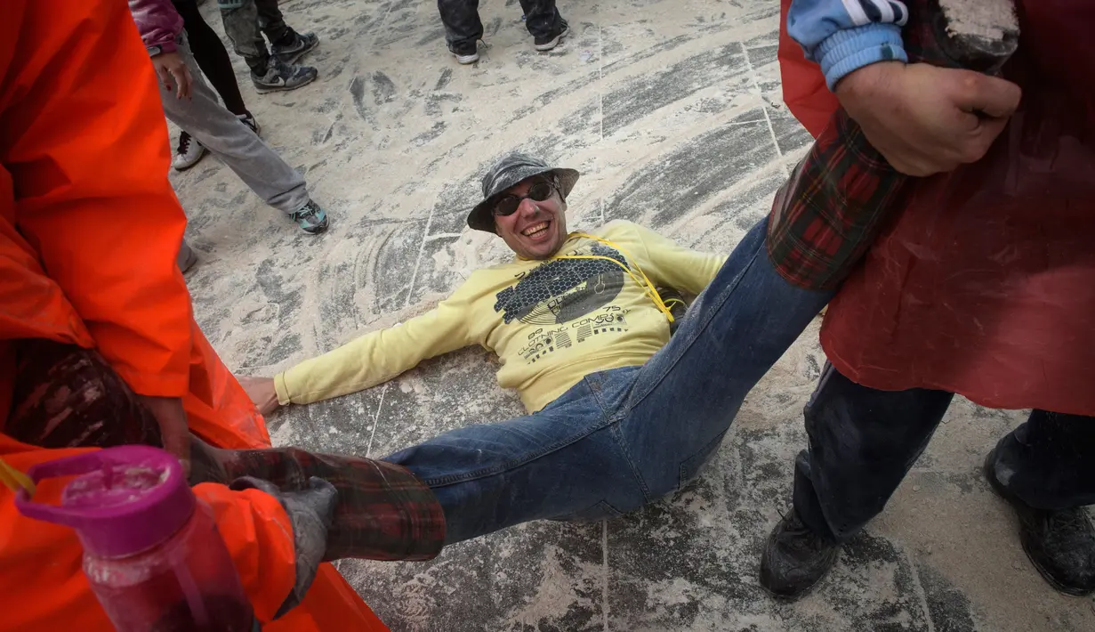 Seorang pria diseret oleh peserta lainnya saat mengikuti festival "Domingo Fareleiro" di desa Xinzo de Limia, Spanyol (21/1). (AFP/Miguel Riopa)