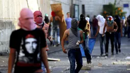 Warga Palestina ikut ambil bagian dalam bentrokan dengan polisi Israel di Shuafat, sebuah daerah pinggiran Arab, Yerusalem, Senin (5/10/2015). Seorang remaja Palestina tewas pada Senin dalam bentrokan di Tepi Barat. (REUTERS/Ammar Awad)