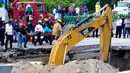 Regu penyelamat mengevakuasi mayat dari lokasi lubang yang menelan sebuah mobil di jalan raya Meksiko-Cuenava, Meksiko, Rabu (12/7). Lubang itu muncul akibat erosi sistem pengeringan yang membentang sekira 15 meter di bawah jalan. (AP/Tony Rivera)