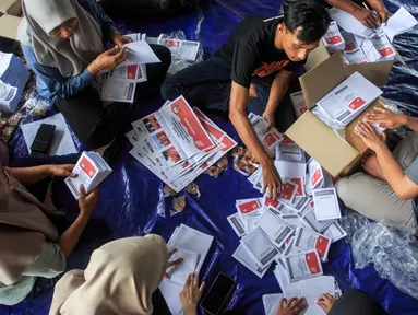 Pekerja melipat surat suara pemilihan presiden yang dijadwalkan pada 14 Februari di Gudang Komisi Pemilihan Umum (KPU) Yogyakarta, Bantul, Kamis (4/1/2024). (DEVI RAHMAN/AFP)