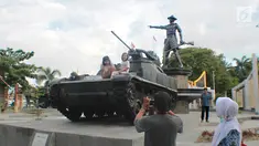 Pengunjung mengambil gambar anaknya di atas tank tempur bersejarah TNI yang berada di Monumen Nani Wartabone di Kilometer Nol Kota Gorontalo, Sabtu (22/9). Keberadaan dua tank tempur jadi buruan warga untuk berswafoto. (Liputan6.com/Arfandi Ibrahim)