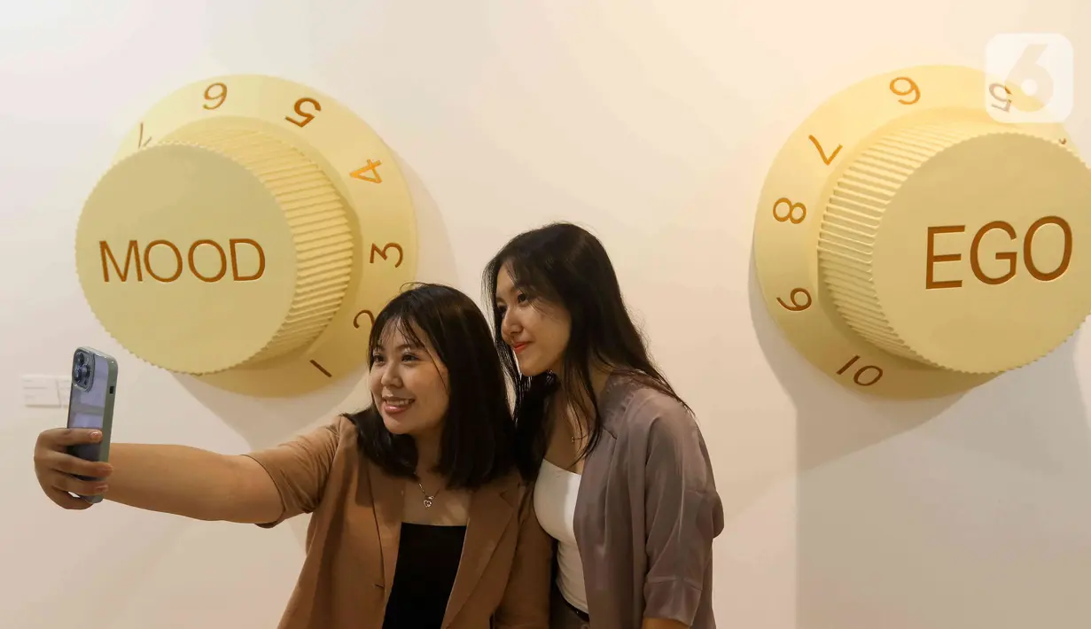 Pengunjung berselfie di dekat karya seni yang ditampilkan dalam pameran Art Jakarta Gardens 2023 di Hutan Kota Plataran, Senayan, Jakarta Pusat, Selasa (7/2/2023). Pameran seni Art Jakarta Gardens kembali digelar tahun ini mulai dari tanggal 7 - 12 Februari 2023, dalam pameran ini, pengunjung dapat menjelajahi kombinasi presentasi karya seni rupa yang ditampilkan dari dalam dan luar ruangan dengan karya berupa patung, instalasi, dan objek dua dimensi. (Liputan6.com/Herman Zakharia)