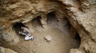 Abdel-Karim Cafran, warga Palestina Beit Hanun mengumpulkan pecahan tembikar di sebuah pemakaman yang baru ditemukan di kebun rumahnya di kota di Jalur Gaza utara, (26/1). (AFP Photo/Mohammed Abed)