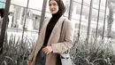 Ciptakan look kasual yang kece dengan padu padan inner dan hijab segi empat hitam, blazer krem, plus celana jeans seperti potret Melody Prima ini. (Instagram/melodyprima).