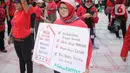 Salah satu peserta aksi yang tergabung dalam Koalisi Sipil Untuk UU Perlindungan PRT mengangkat poster di depan Gedung DPR, Jakarta, Rabu (15/7/2023). Dalam aksinya, pendemo yang sebagian besar ibu-ibu ini juga membawa spanduk dan poster berisi tuntutan mereka. (Liputan6.com/Faizal Fanani)
