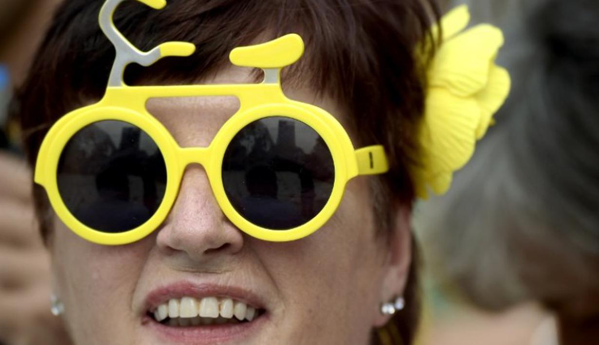 Seorang wanita menggunakan kacamata berbentuk sepeda untuk menyambut lomba balap sepeda Tour de France di Taman Lepelenburg, Utrecht, Belanda. (2/7/2015). (AFP PHOTO/Lionel Bonaventure)