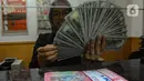 Petugas valas menghitung mata uang dolar AS di DolarAsia Valas di kawasan BSD, Tangerang Selatan, Banten, Selasa (16/4/2024). (merdeka.com/Arie Basuki)