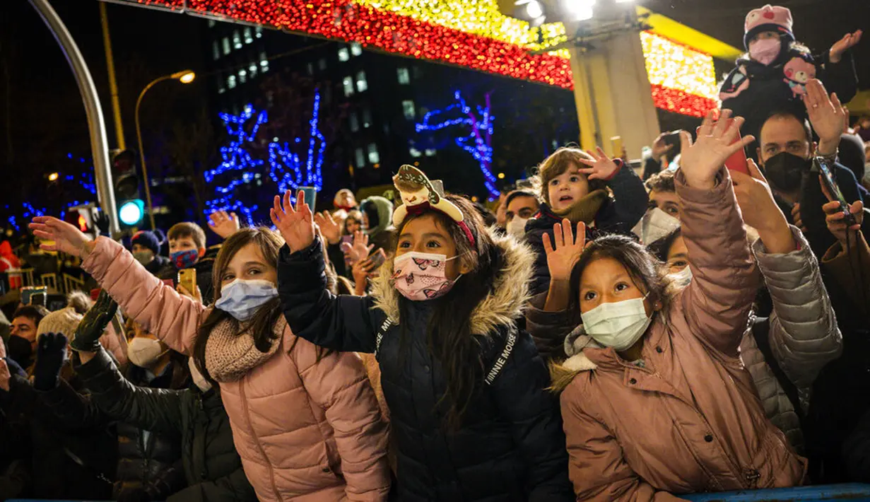 Anak-anak menghadiri parade Cabalgata de Reyes di Madrid, Spanyol, 5 Januari 2022. Parade warna-warni ini dalam rangka merayakan Epiphany saat umat Kristen memperingati kunjungan Tiga Raja atau Tiga Orang Bijaksana ke bayi Yesus. (AP Photo/Bernat Armangue)