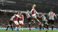 Aksi pemain Arsenal, Laurent Koscielny (tengah) menyundul bola melewati adangan para pemain Newcastle pada lanjutan Premier League di Emirates Stadium, London, (16/12/2017). Arsenal menang 1-0. (AFP/Glyn Kirk)