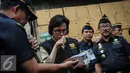 Menteri Keuangan Sri Mulyani mencium tembakau rokok ilegal di Kantor Dirjen Bea Cukai, Jakarta, Jumat (30/9). Sri Mulyani mengaku takjub dengan temuan rokok ilegal yang sudah terkemas rapi. (Liputan6.com/Faizal Fanani)