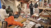 Petugas melakukan penyelidikan di lokasi bom bunuh diri meledak di kota Kano, Nigeria,  Rabu (18/11). (REUTERS / Stringer )
