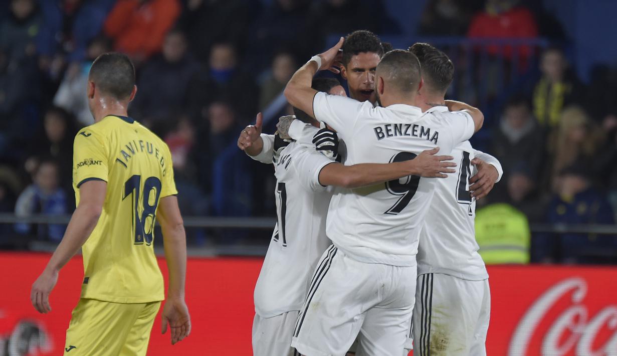 5. Pemain Real Madrdi merayakan gol pertama yang dicetak Karim Benzema pada laga lanjutan LaLiga yang berlangsung di Stadion DeLa Ceramica, Spanyol, Jumat (4/12). Real Madrid ditahan imbang Villareal 2-2.  (AFP/Jose Jordan)