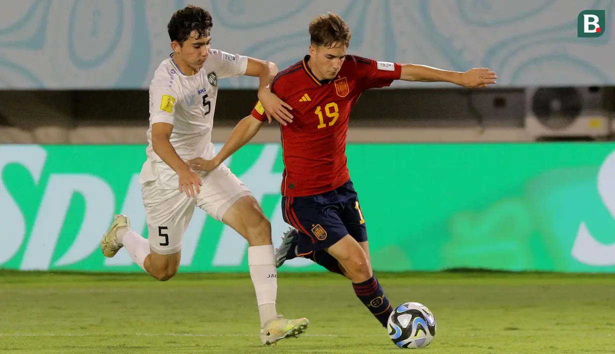 Pemain Timnas Spanyol U-17, Daniel Yanez (kanan), mengontrol bola dibayangi pemain Timnas Uzbekistan U-17, Azizbek Tulkunbekov dalam laga pamungkas Grup B Piala Dunia U-17 2023 yang berlangsung di Stadion Manahan, Solo, Kamis (16/11/2023) sore WIB. (Bola.com/Arief Bagus Prasetiyo)