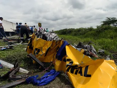 Puing-puing sisa tabrakan antara bus sekolah dengan truk di dekat kota pesisir Yaguachi-Milagro, Ekuador, Jumat (14/1). Dilaporkan sedikitnya 20 orang tewas dan 17 lainnya mengalami luka-luka. (AFP PHOTO/MAURICIO DE LA CADENA)