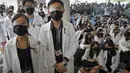 Perawat dan staf medis mengenakan penutup mata dan masker saat unjuk rasa di sebuah rumah sakit di Hong Kong (13/8/2019). Mereka memprotes kebrutalan polisi yang menurut mereka terjadi selama demonstrasi anti-pemerintah berlangsung pada akhir pekan. (AP Photo/Kin Cheung)