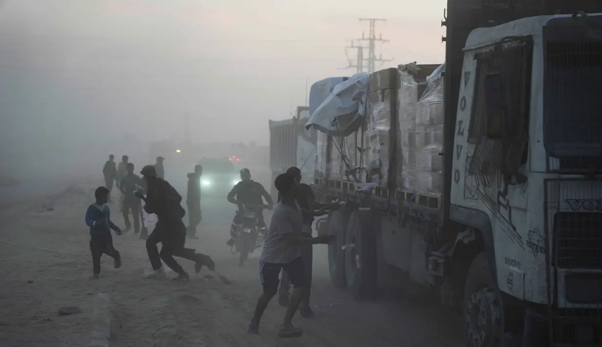 Warga Palestina berbondong-bondong menuju truk yang mengangkut bantuan dari Program Pangan Dunia (WFP) saat truk-truk tersebut melintasi Deir al-Balah di Gaza Tengah, Sabtu, 8 November 2025. Situasi kemanusiaan di Gaza, yang sebagian besar wilayahnya luluh lantak, masih memprihatinkan. (AP Photo/Abdel Kareem Hana)