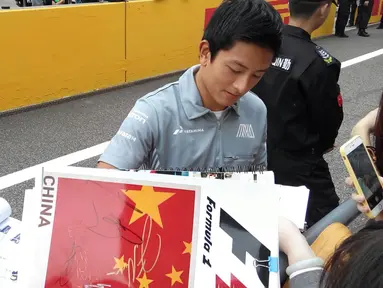 Rio Haryanto melayani tanda tangan fans saat berada di Sirkuit Internasional Shanghai, China, (14/4/2016). (Bola.com/Rio Haryanto Media)