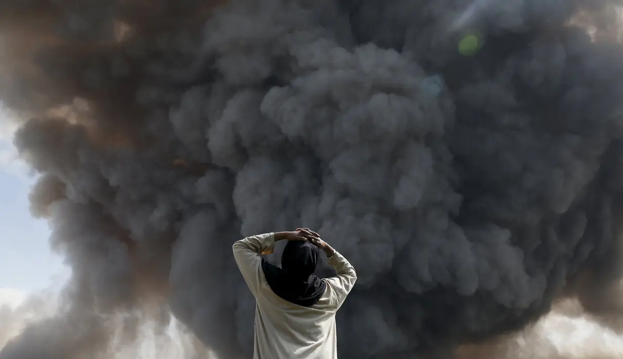 Reaksi seorang warga saat melihat Gunung Sinabung melontarkan awan panasnya di Desa Tiga Serangkai, Karo, Sumatera Utara, Rabu (24/6/2015). (REUTERS/Beawiharta)