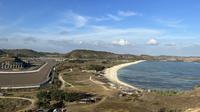 Suasana Sirkuit Mandalika yang berbatasan dengan pantai pesisir Selatan Pulau Lombok dilihat dari atas Bukit Seger, Lombok, Jumat (11/8/2023) yang menjadi spot menarik menyaksikan balapan. (Bola.com/Iqri Widya)