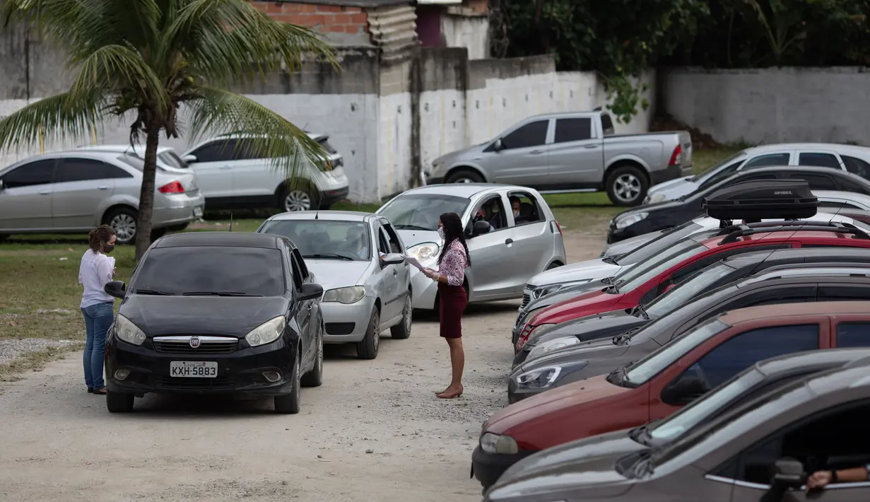 Antrean mobil berisi pasangan yang akan menjalani pernikahan drive-thru di kantor pencatatan sipil di Santa Cruz, Rio de Janeiro, Brasil, 28 Mei 2020. Fasilitas ini untuk memudahkan dan membantu pasangan yang ingin mengesahkan hubungan saat pandemi covid-19. (AP/Silvia Izquierdo)