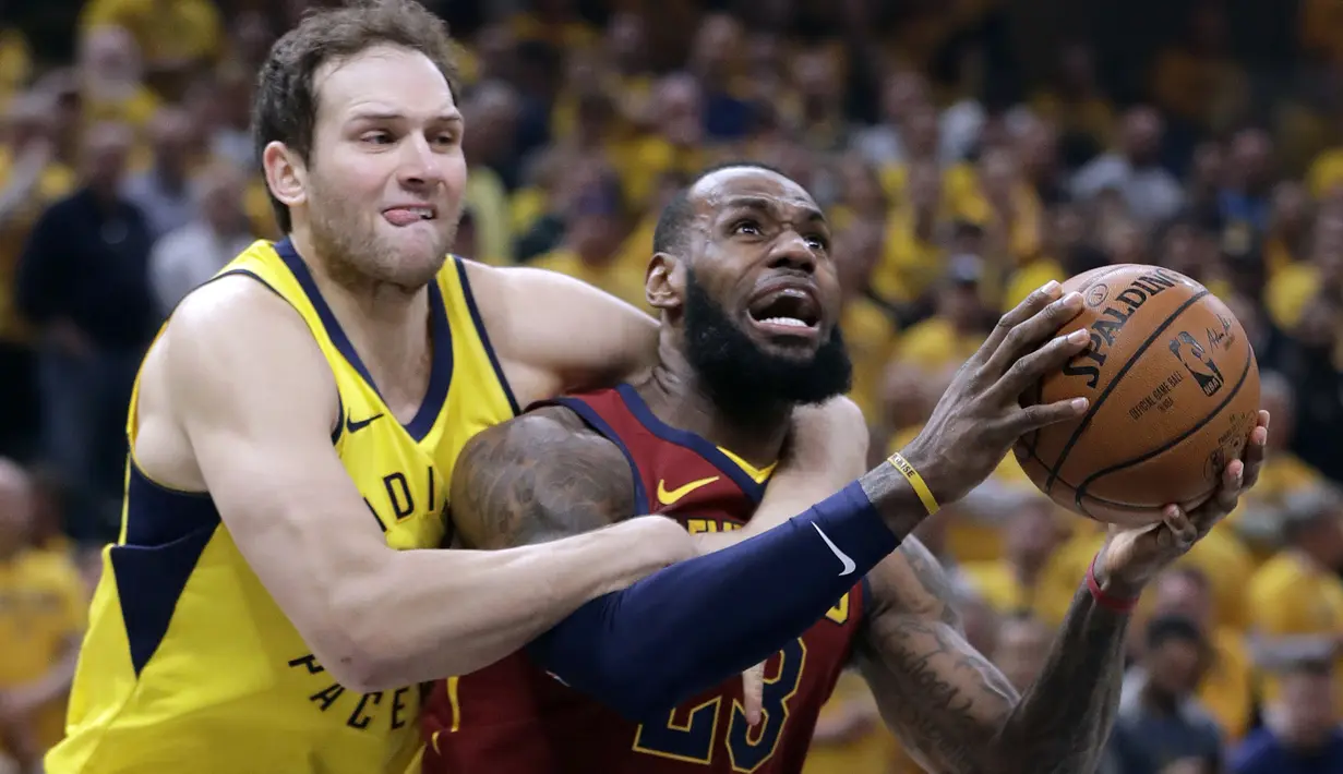 Pemain Cleveland Cavaliers, LeBron James (kanan) dilanggar pemain Indiana Pacers, Bojan Bogdanovic pada game keenam playoffs NBA basketball di Bankers Life Fieldhouse, Indianapolis, (27/4/2018). Pacers menang 121-87. (AP/Darron Cummings)