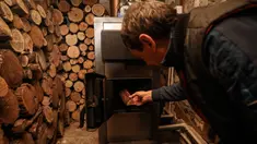 Tudor Popescu memasukkan kayu bakar ke tungku di ruang penyimpanan yang terpasang di rumahnya di Chisinau, Moldova, 15 Oktober 2022. Krisis energi yang melanda Eropa karena dipicu pemotongan aliran gas alam oleh Rusia di tengah perangnya melawan Ukraina telah memaksa beberapa orang untuk beralih ke kayu bakar untuk menghangatkan diri dalam cuaca yang beranjak dingin. (AP Photo/Aurel Obreja)