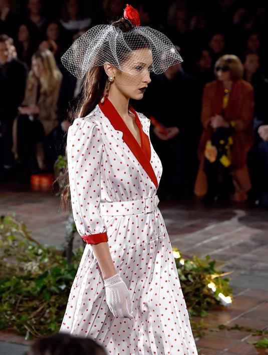 Bella Hadid berjalan di catwalk untuk show Rodarte pada New York Fashion Week: The Shows di New York City, Selasa (11/2/2020). Bella Hadid seolah-olah kembali ke era tahun 50an dalam balutan gaun polkadot merah dan putih dengan kerudung yang menutupi wajahnya. (Dimitrios Kambouris/Getty Images/AFP)