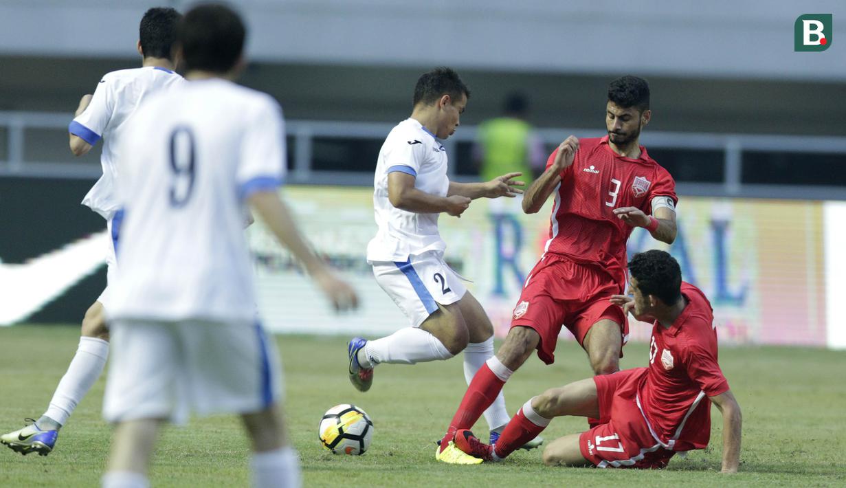 Pemain Uzbekistan, Kodirkulov Sanjar, berusaha melewati pemain Bahrain pada laga PSSI Anniversary Cup 2018 di Stadion Pakansari, Senin (30/4/2018). Uzbekistan bermain imbang 3-3 dengan Bahrain. (Bola.com/M Iqbal Ichsan)