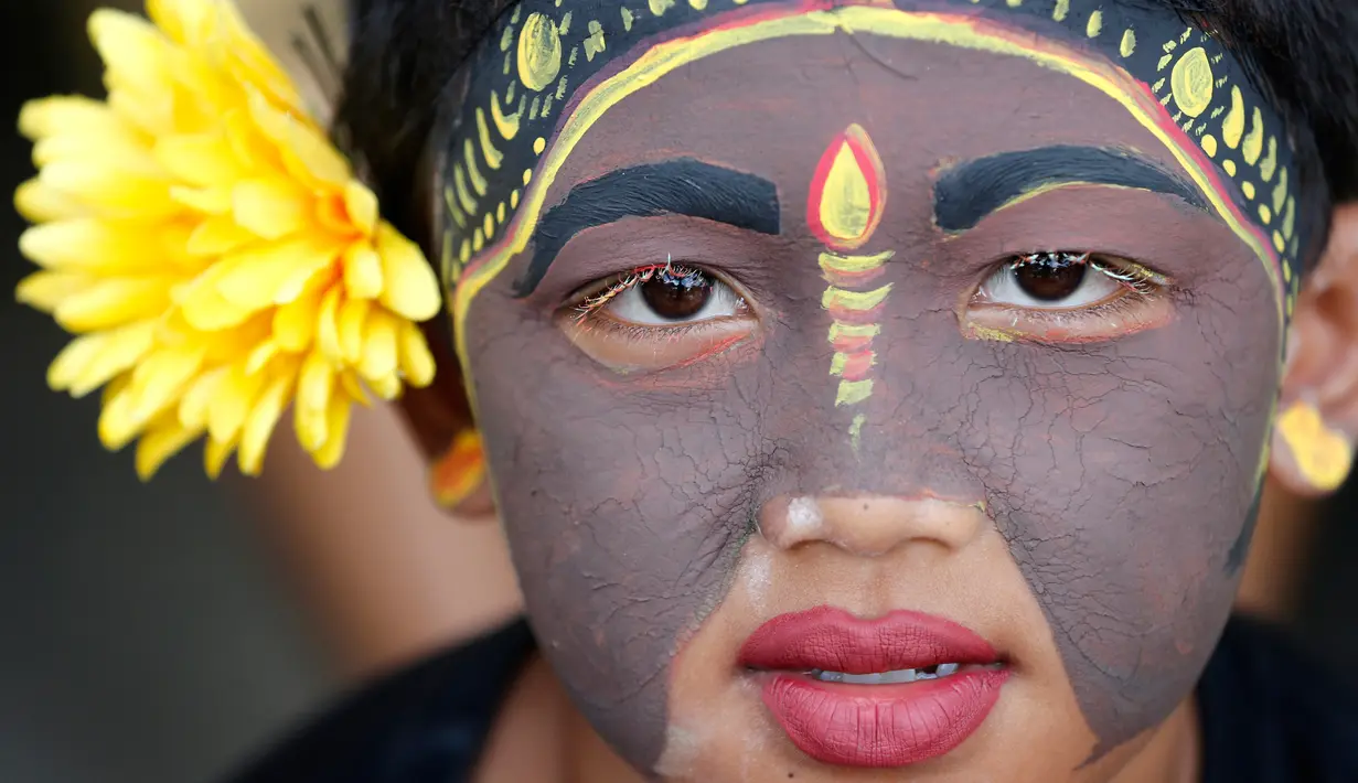 Seorang pemuda berpartisipasi dalam ritual Hindu "Grebeg" di Desa Tegallalang, Bali, Rabu (30/1). Dalam ritual dua tahunan ini, para pemuda berkeliling kampung dengan riasan tubuh warna-warni untuk menangkal Roh jahat. (AP/Firdia Lisnawati)