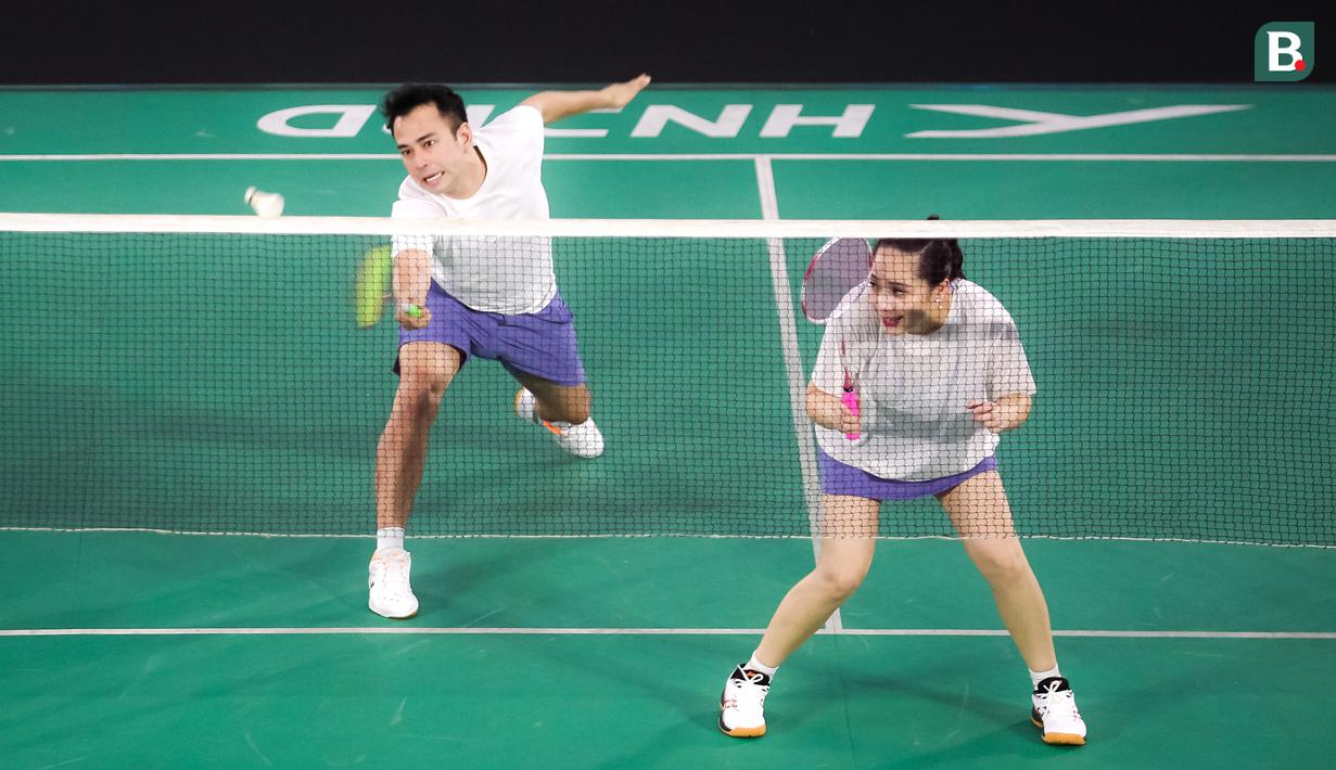 Pasangan selebritas Raffi Ahmad dan Nagita Slavina berusaha mengembalikan kok saat bertanding melawan pasangan Rizky Billar dan Lesti Kejora pada laga bulu tangkis ganda campuran Turnamen Olahraga Selebriti Indonesia (TOSI) di GOR UNJ, Jakarta, Minggu (16/07/2023). Raffi dan Gigi kalah dua set langsung dari Rizky Billar dan Lesti dengan skor 12-21, 10-21.(Bola.com/Bagaskara Lazuardi)