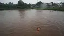 Seorang anak bermain di lapangan yang terendam banjir di kawasan Kemang, Jakarta, Kamis (16/11). Tingginya intensitas hujan dan pesatnya pembangunan menyebabkan kawasan tersebut langganan banjir karena luapan Kali Krukut. (Liputan6.com/Immanuel Antonius)