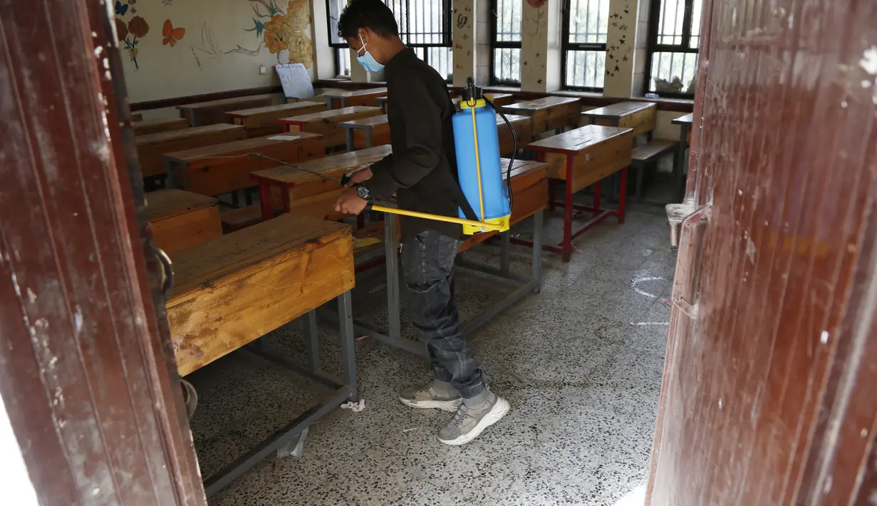 Seorang petugas kesehatan mendisinfeksi sebuah ruang kelas sebelum para siswa datang untuk mengikuti ujian di sebuah sekolah di Sanaa, Yaman (30/8/2020). (Xinhua/Mohammed Mohammed)