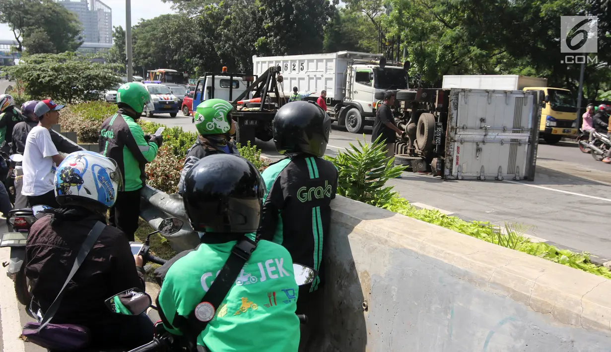 Sejumlah ojek online melihat mobil boks terguling di Jalan Casablanca, Jakarta, Rabu (27/6). Mobil bernomor polisi B 9515 FCC terguling di ruas jalan dari arah Tebet menuju Jalan Prof Dr Satrio pukul 10.35 WIB. (Liputan6.com/Arya Manggala)